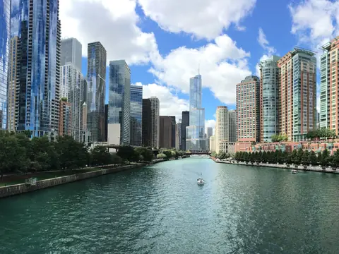 The Chicago River and its towers under a blue sky with clouds