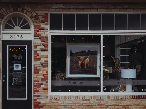 A brick storefront with a large window and an arched door