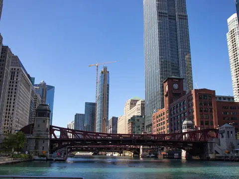 A red bridge over the Chicago River with towers behind it