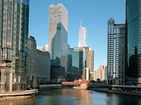 Downtown Chicago towers along the river under a clear blue sky