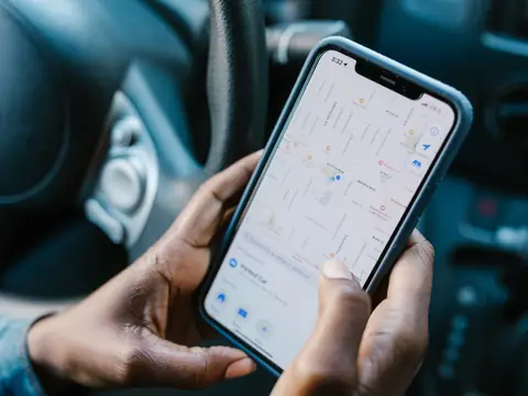 Hands holding a phone showing a map app