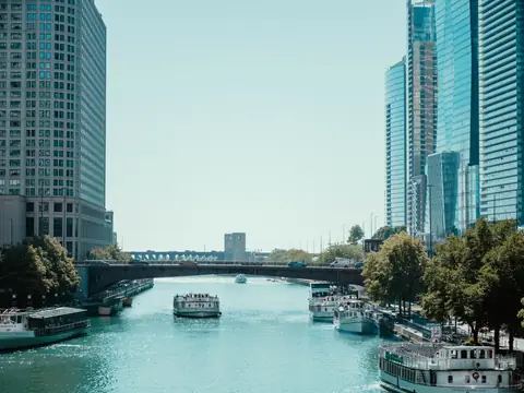Tour boats on the Chicago River between tall buildings