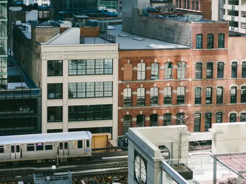 Brick and white loft buildings above an 'L' train in Chicago