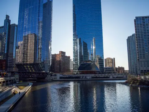 Glass towers reflected in the Chicago River on a clear day