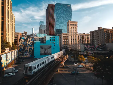An 'L' train on the elevated tracks below the West Loop's towers